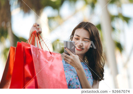 dult asian influencer woman shopping  and take photo with smartphone 92667074