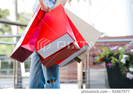 Asian woman standing hold a red shopping bag on day time. 92667077
