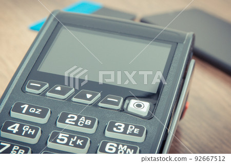 Payment terminal, credit card and smartphone. Cashless paying for shopping. Finance concept 92667512