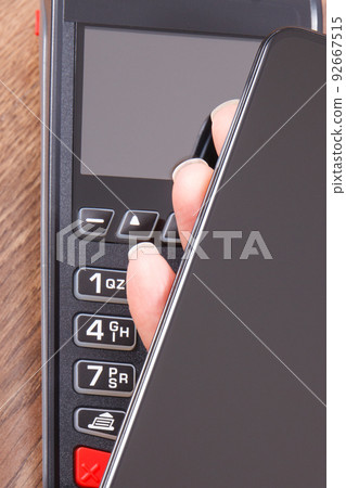 Mobile phone or smartphone with payment terminal. Credit card reader 92667515