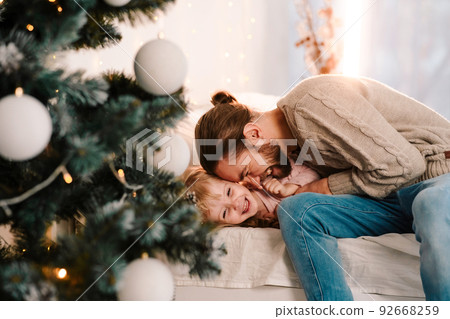 Happy father plays with his daughter who lying on the bed 92668259