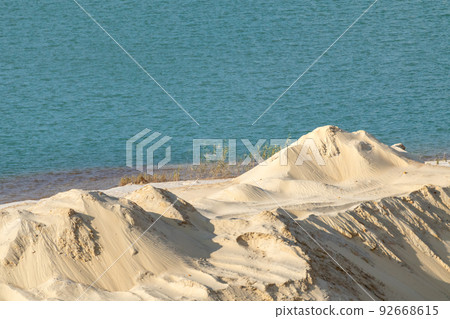 Yellow sand dunes and blue water desert terrain. Yellow sand dunes and blue water desert terrain. 92668615