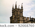 The top of a Gothic castle in close-up against a cloudy sky and 92668760