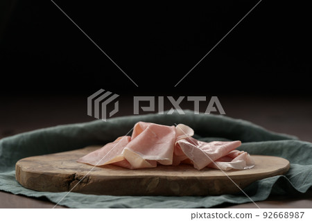 Thin slices of prosciutto cotto on olive wood board 92668987