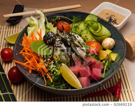 a traditional Hawaiian poke dish with tuna and sauce. close-up a traditional Hawaiian poke dish with tuna and sauce. close-up 92669219