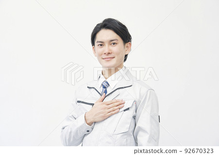 一個微笑的工人的肖像，他把手放在胸前 白色背景 92670323