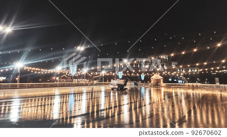 Night clear ice skating rink with cleaning machine Night clear ice skating rink with cleaning machine 92670602