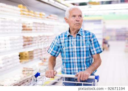 elderly retired senor buying groceries in supermarket 92671194