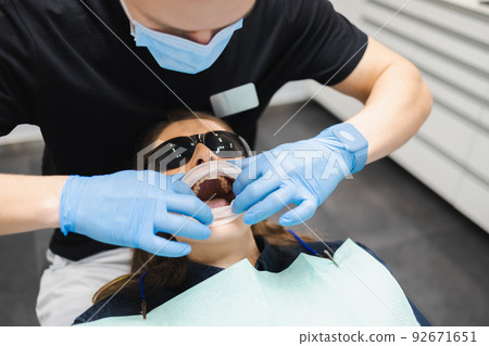 Female dental doctor puts a mouth dilator for comfort dental treatment to the patient 92671651