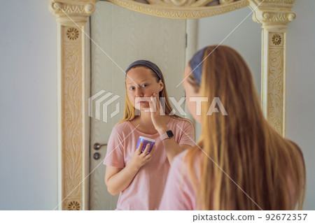 Happy girl excited with cosmetic effect of beauty care product, rejuvenating cream, reducing wrinkles lotion, looking in mirror with open mouth in amazement. Skincare concept Happy girl excited with cosmetic effect of beauty care product, rejuvenating cream, reducing wrinkles lotion, looking in mirror with open mouth in amazement. Skincare concept 92672357