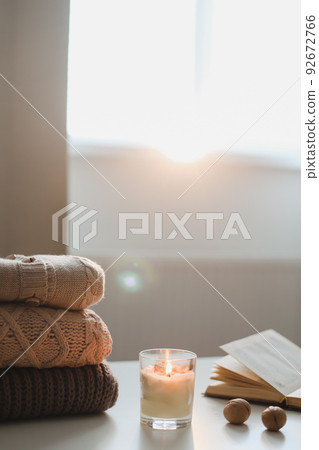 cozy comfortable hygge home atmosphere and still life with a cup, candle, book and sweaters cozy comfortable hygge home atmosphere and still life with a cup, candle, book and sweaters 92672766