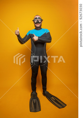 Diver man showing thumb up on yellow background, traveling concept. Diver man showing thumb up on yellow background, traveling concept. 92673030