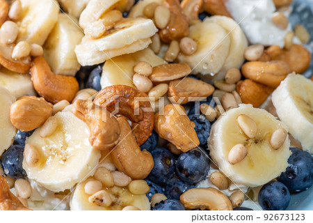 Beautiful breakfast - cottage cheese, berries cashew, cedar, blueberry and honey in the plate. Good morning. Beautiful breakfast - cottage cheese, berries cashew, cedar, blueberry and honey in the plate. Good morning. 92673123