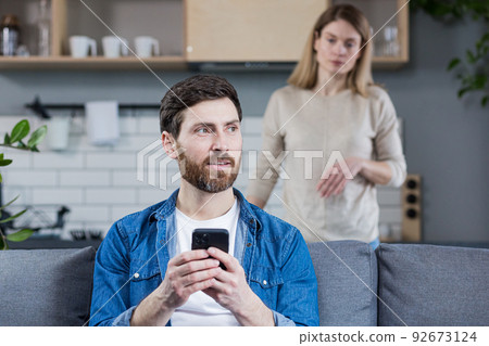 Jealous wife quarrels over husband who uses phone, and keeps in touch with mistress, family quarrel and conflict 92673124
