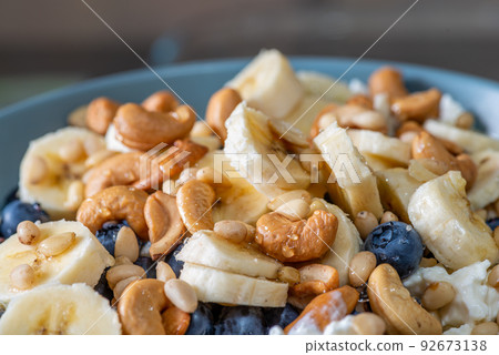 Beautiful breakfast - cottage cheese, berries cashew, cedar, blueberry and honey in the plate. Good morning. Beautiful breakfast - cottage cheese, berries cashew, cedar, blueberry and honey in the plate. Good morning. 92673138