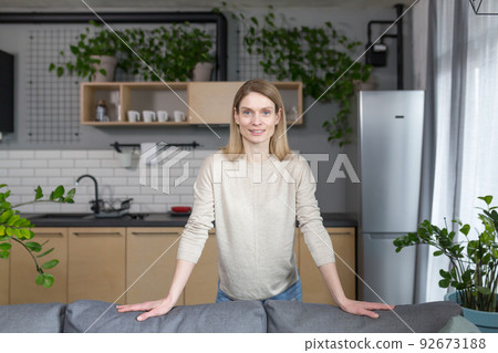 Portrait of a successful and happy woman at home, smiling and looking at the camera Portrait of a successful and happy woman at home, smiling and looking at the camera 92673188