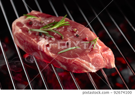 Raw steak on a grill. 92674100