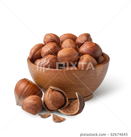 Bowl of hazelnuts with green leaves isolated on white. Deep focus 92674845