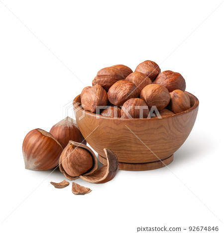 Wooden bowl full of hazelnuts isolated on white. Deep focus 92674846