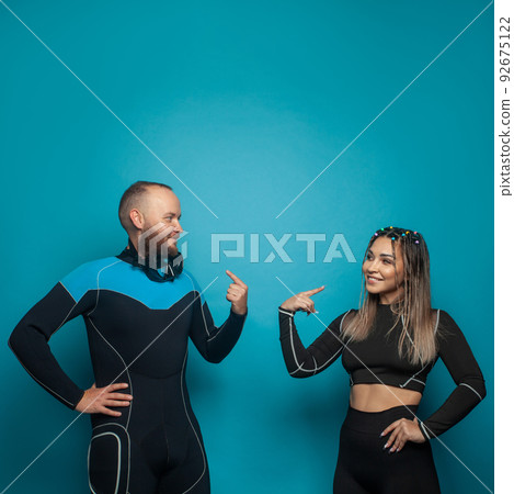 Cute friends in sportswear smiling while standing together on blue background 92675122