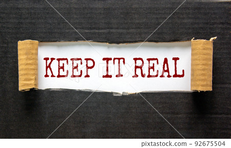 The words 'keep it real' appearing behind torn black paper. Beautiful background. Business concept. 92675504