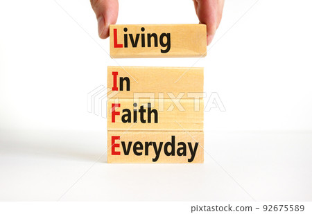 LIFE living in faith everyday symbol. Concept words LIFE living in faith everyday on wooden blocks on white background. Businessman hand. Business LIFE living in faith everyday concept. Copy space. LIFE living in faith everyday symbol. Concept words LIFE living in faith everyday on wooden blocks on white background. Businessman hand. Business LIFE living in faith everyday concept. Copy space. 92675589