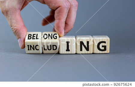 Including or belonging symbol. Businessman hand turns cubes and changes the word 'including' to 'belonging'. Beautiful grey background. Business and Including or belonging concept. Copy space. 92675624