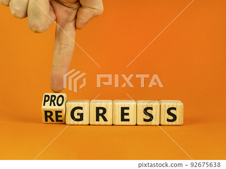 Regress or progress symbol. Businessman turns wooden cubes and changes the word Regress to Progress. Beautiful orange table orange background. Business regress or progress concept. Copy space. Regress or progress symbol. Businessman turns wooden cubes and changes the word Regress to Progress. Beautiful orange table orange background. Business regress or progress concept. Copy space. 92675638
