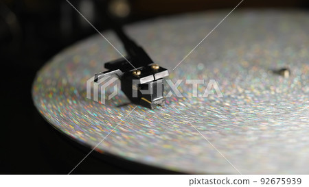 Retro-styled spinning silver record vinyl player. Close up glitter surface. Rotating vintage 92675939