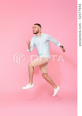 man in summer clothes jumping on pink background. man in summer clothes jumping on pink background. 92677648