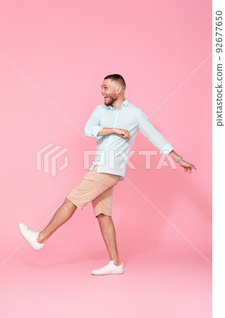 cheerful young happy man dance on pink background. cheerful young happy man dance on pink background. 92677650