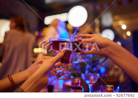 people at the bar try tinctures, red tinctures in glasses, alcoholic shots. people at the bar try tinctures, red tinctures in glasses, alcoholic shots. 92677692