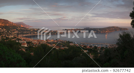 View from Mont Boron hill. Panorama view of the city and Cap Ferrat with a purple sky and a feeling of relaxation in the early evening. View from Mont Boron hill. Panorama view of the city and Cap Ferrat with a purple sky and a feeling of relaxation in the early evening. 92677742