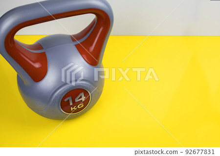 a sports kettlebell on a yellow background. Healthy lifestyle. 92677831