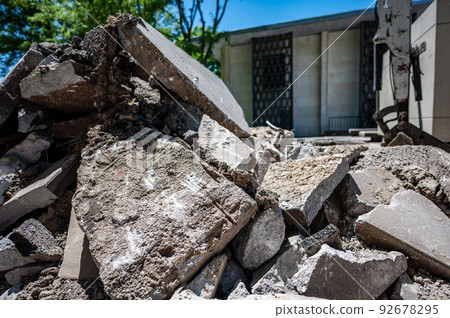Sidewalk being replaced and old slabs broken and pilled at construction site.  92678295
