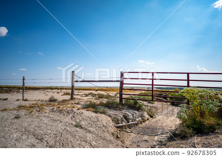 Water gap under a livestock fence where animals can go under a washed out section Water gap under a livestock fence where animals can go under a washed out section 92678305