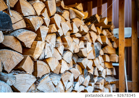 Stacked dry split wood for heating in a northern cold climate. 92678345