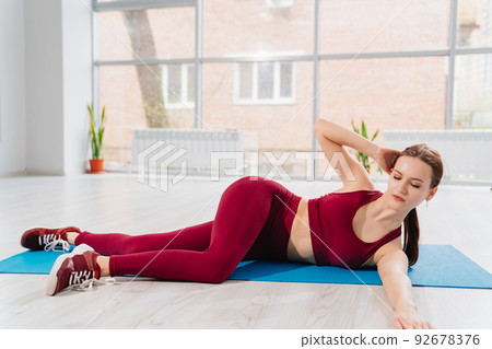 a beautiful and athletic girl in a burgundy tracksuit does exercises a beautiful and athletic girl in a burgundy tracksuit does exercises 92678376