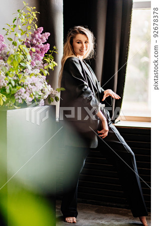 a sexy blonde topless woman in a jacket in a dark room by the window. a sexy blonde topless woman in a jacket in a dark room by the window. 92678378