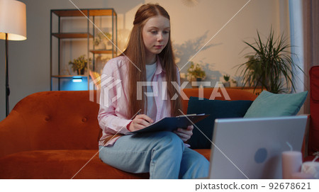 Child girl accounting payments calculating monthly expenses bank bills, analysing paperwork at home Child girl accounting payments calculating monthly expenses bank bills, analysing paperwork at home 92678621
