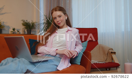 Teen child girl kid freelancer working on laptop, sends messages, makes online purchases at home Teen child girl kid freelancer working on laptop, sends messages, makes online purchases at home 92678622