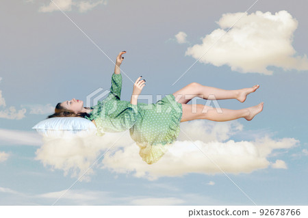 Sleeping beauty floating in air. Relaxed girl in vintage ruffle dress keeping eye closed, lying on pillow levitating, flying in dream with hands up to catch. collage composition on day cloudy blue sky 92678766