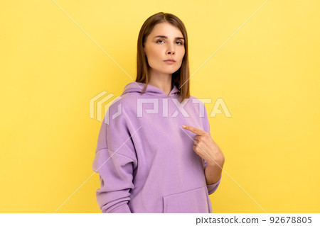 This is me. Egoistic haughty woman pointing herself and looking at camera with arrogance, superiority, proud of achieved goal, wearing purple hoodie. Indoor studio shot isolated on yellow background. This is me. Egoistic haughty woman pointing herself and looking at camera with arrogance, superiority, proud of achieved goal, wearing purple hoodie. Indoor studio shot isolated on yellow background. 92678805