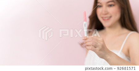 happy pregnant woman holding and showing positive pregnancy test 92681571