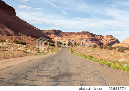 Scenic Road in the Dry Desert with Red Rocky Mountains in Background. Scenic Road in the Dry Desert with Red Rocky Mountains in Background. 92681774