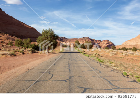 Scenic Road in the Dry Desert with Red Rocky Mountains in Background. Scenic Road in the Dry Desert with Red Rocky Mountains in Background. 92681775