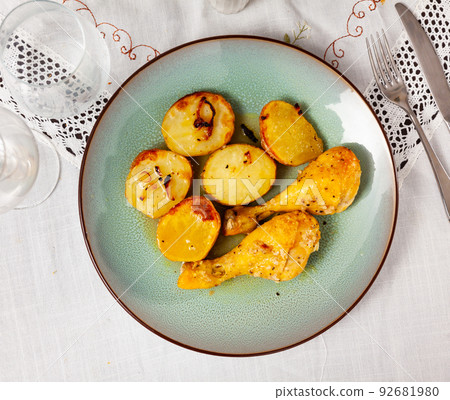 Barbecued chicken leg with boiled potatoes closeup on plate Barbecued chicken leg with boiled potatoes closeup on plate 92681980