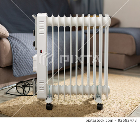 Electric oil heater on floor in room 92682478