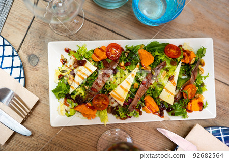 Salad of fresh lettuce with romesco sauce, anchovy fillets and cheese Salad of fresh lettuce with romesco sauce, anchovy fillets and cheese 92682564