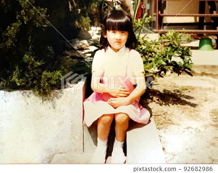 昭和 50 年代一個拿著球坐在戶外的女孩 92682986